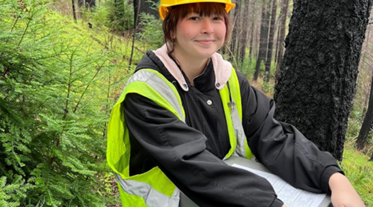 Student with clipboard in forest