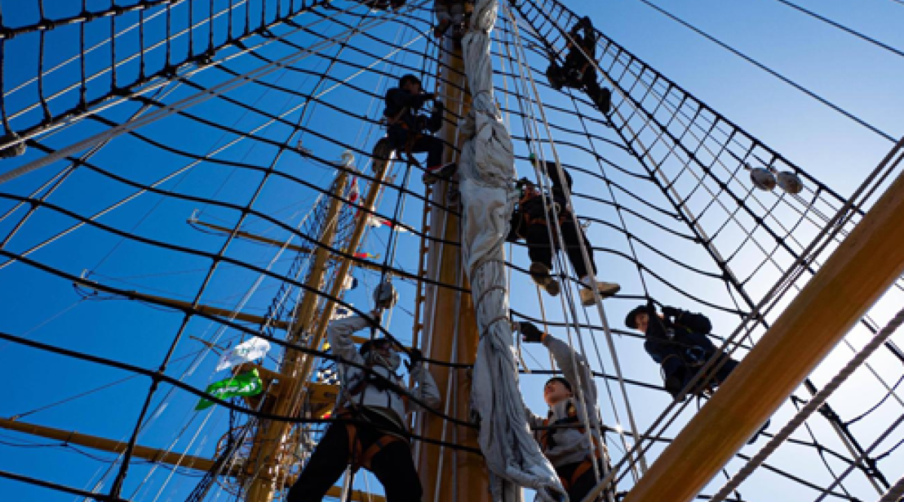 Students climbing a sailing mast