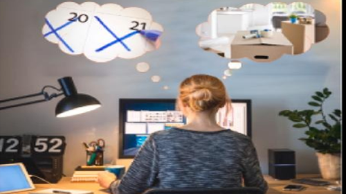 Woman at desk thinking about work travel plans