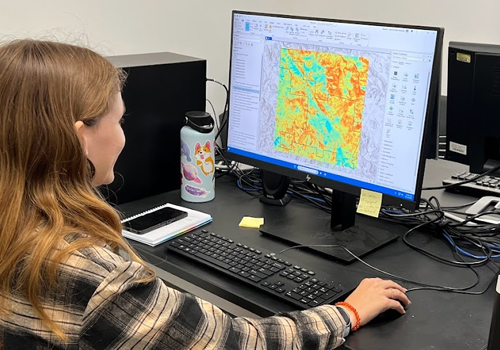 Student at computer looking at a map