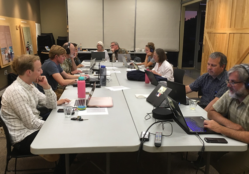 Students, faculty and citizens working around a table