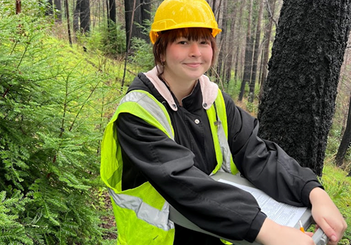 Student with clipboard in forest