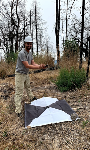 Student standing near remote sensing calibration target