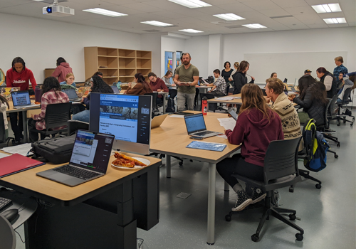 Students sitting around tables collaborating